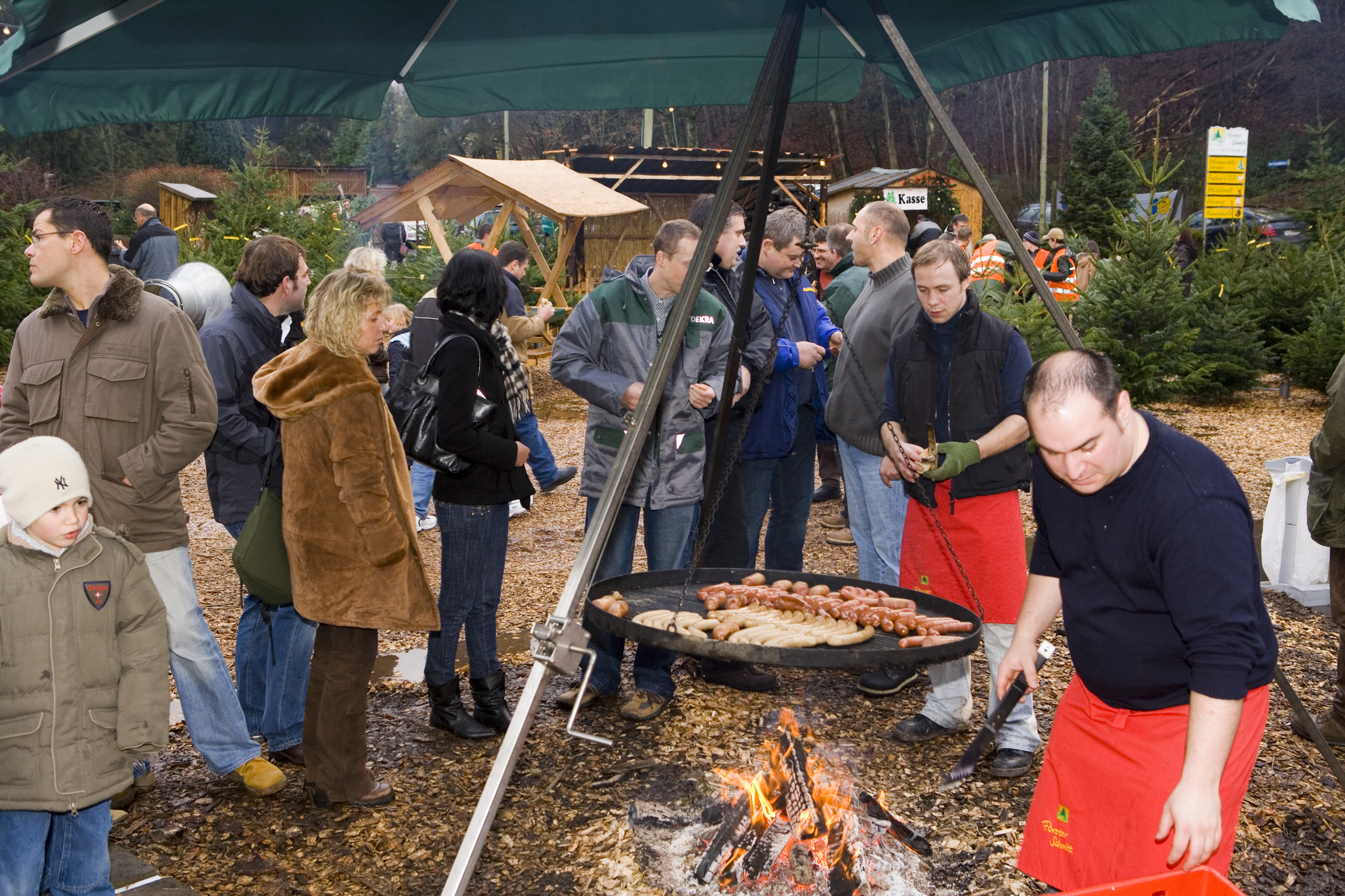 Grill und Gäste beim Weihnachtsbaumfest